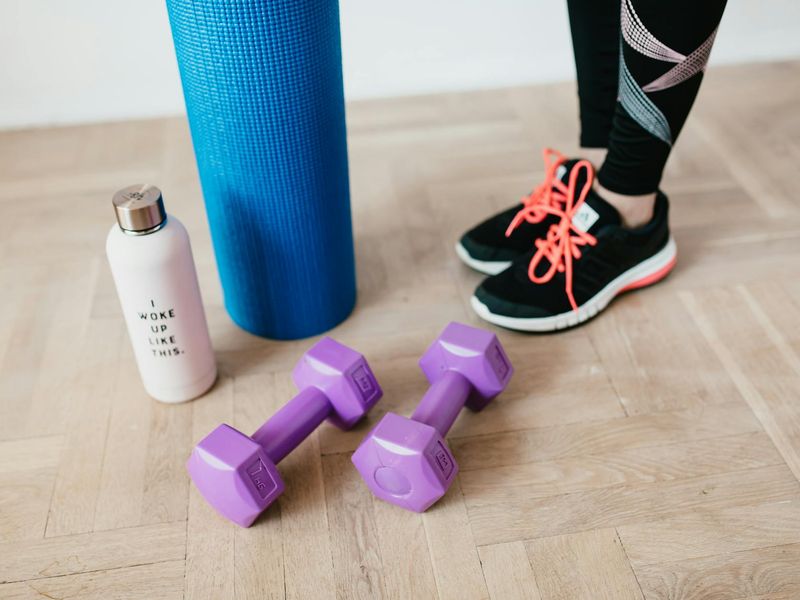 Close up of yoga mat and accessories on a clean floor.